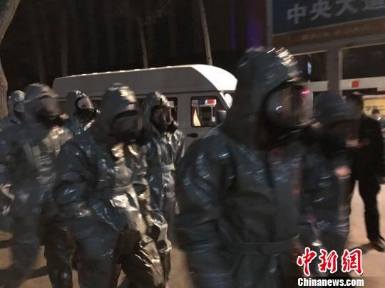 十几名身着防护服的人员头戴面具进入事发地。　胡健 摄